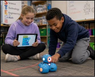 Campers programming a robot with a tablet